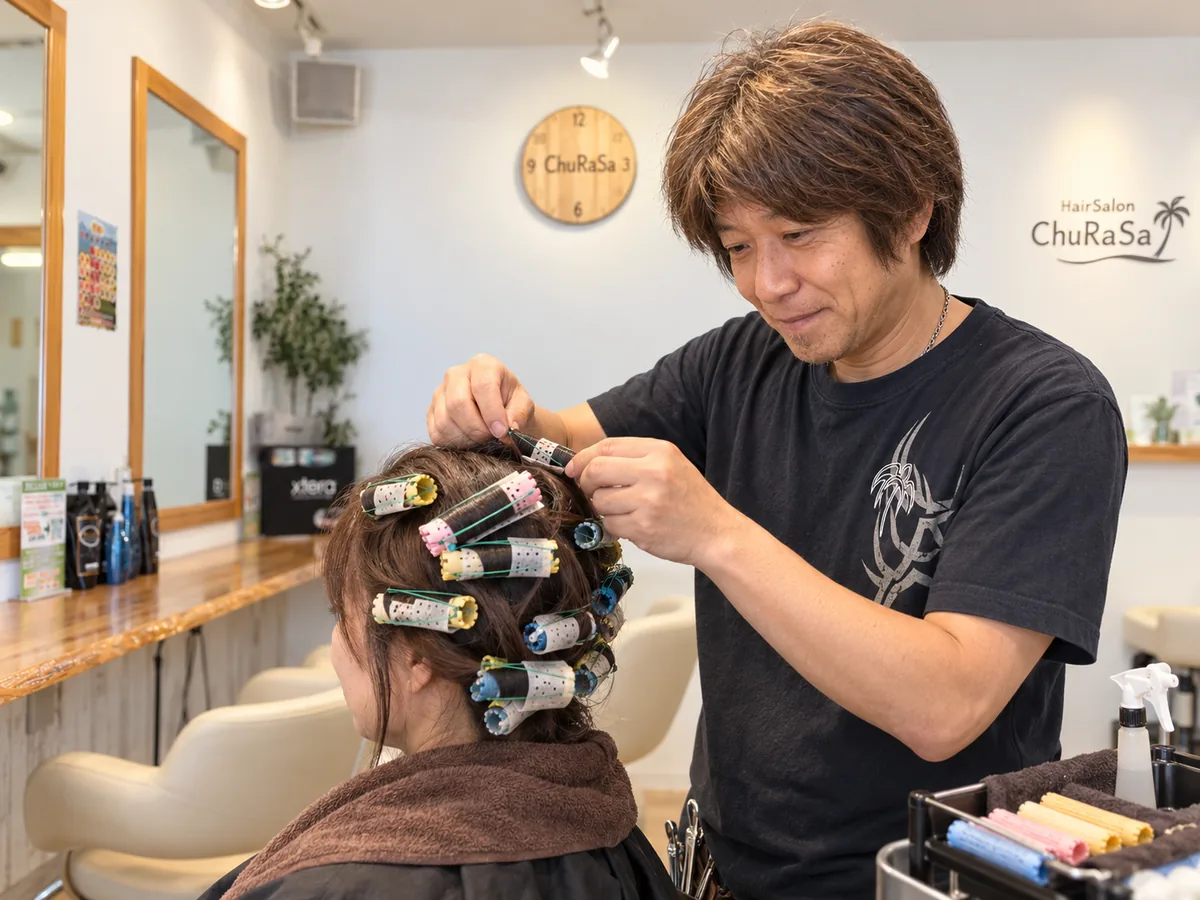 HairSalon ChuRaSaでスタイリストがお客様の髪にロッドを巻いてパーマ施術しているイメージ